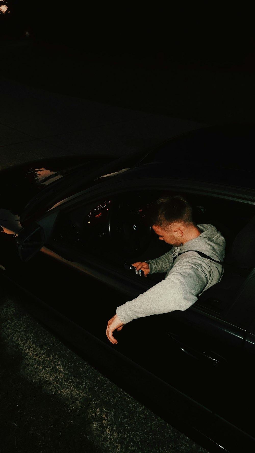 a man leaning out of a car window at night