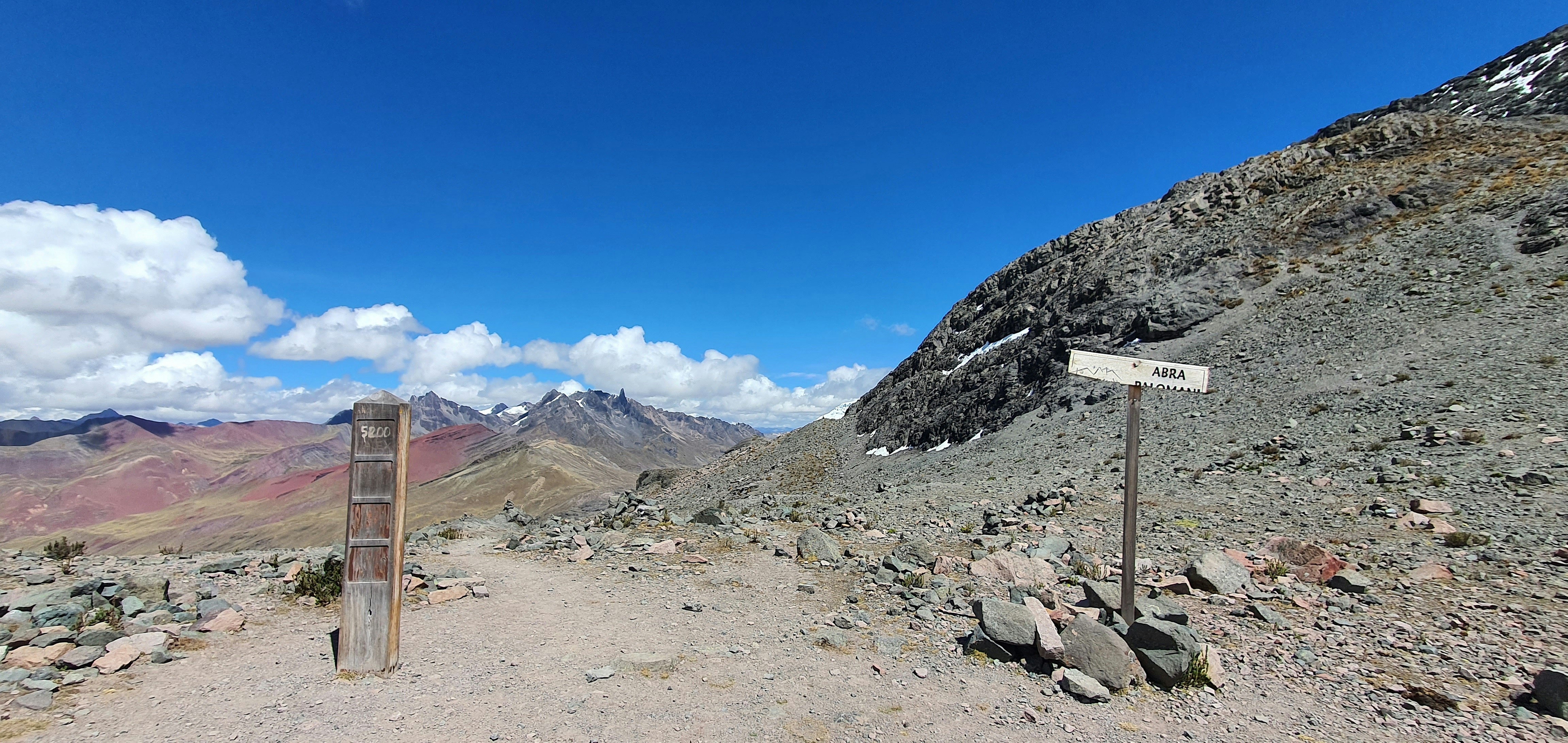 a sign on the side of a mountain with a sky background