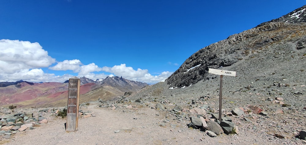 a sign on the side of a mountain with a sky background