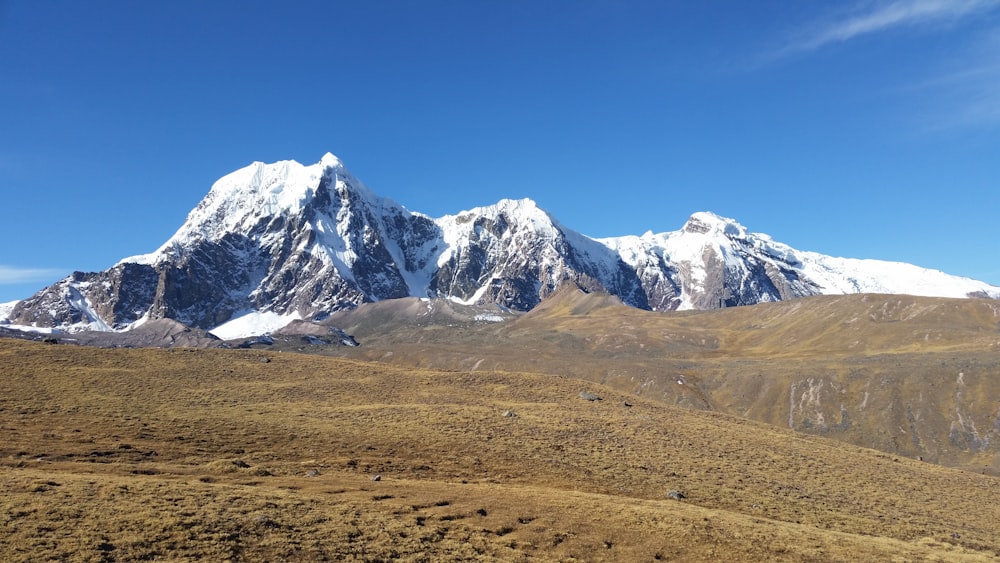 a mountain range with snow capped mountains in the background