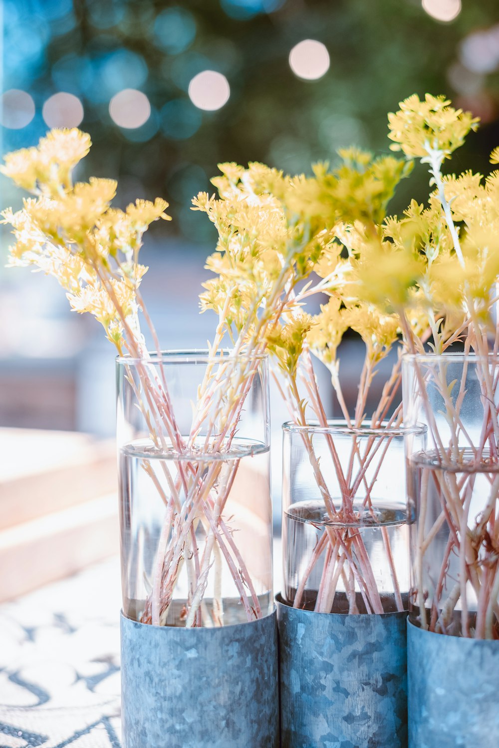 um par de vasos cheios de flores em cima de uma mesa