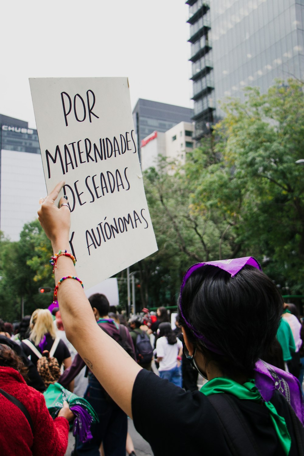 a woman holding a sign in a crowd