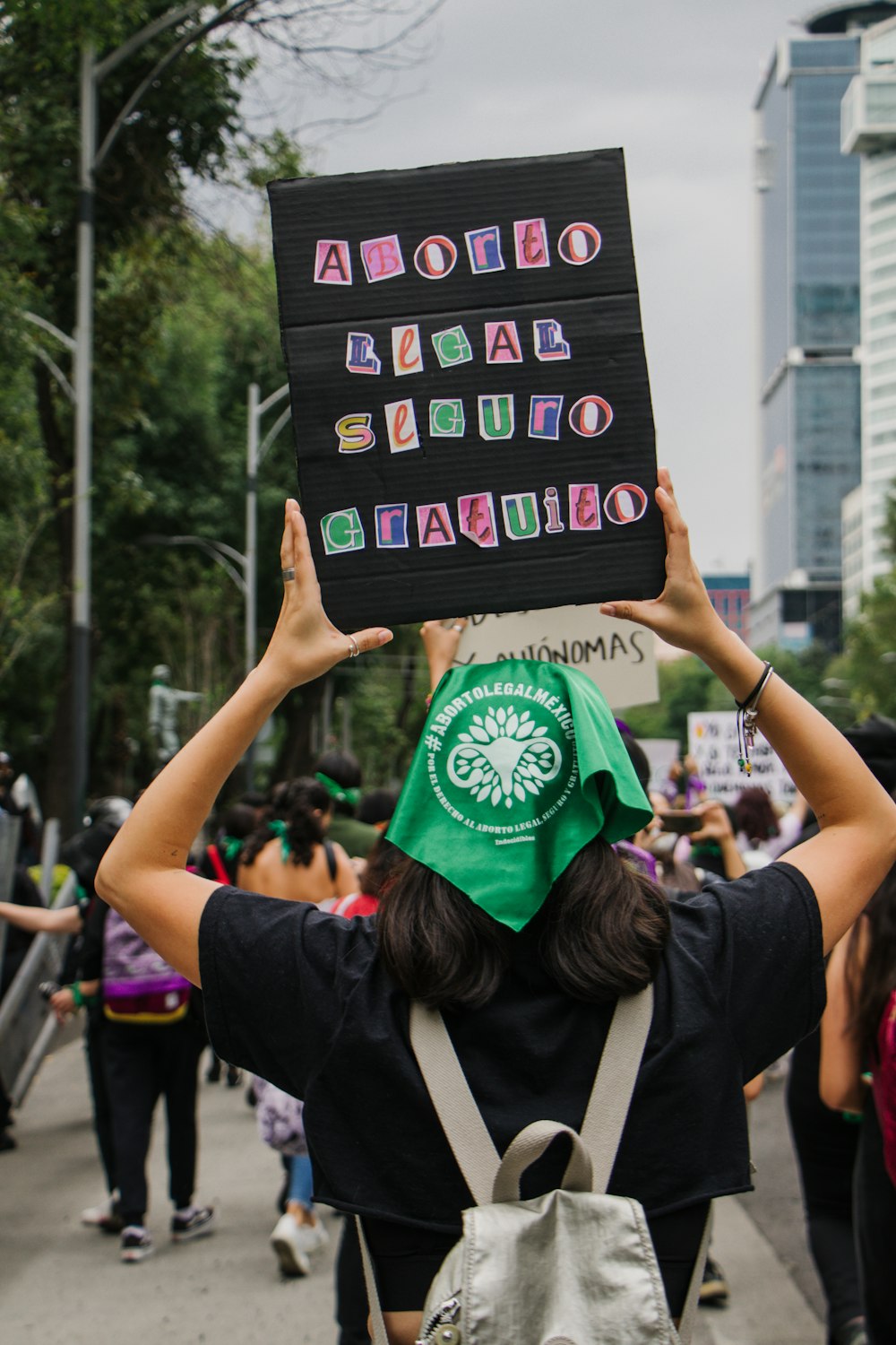 a woman holding up a sign with letters on it