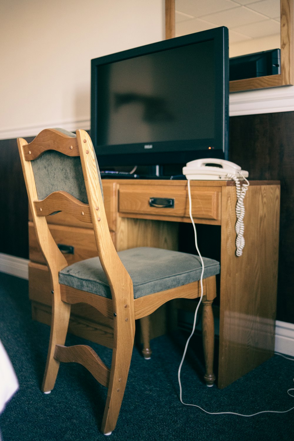 a wooden chair sitting in front of a tv