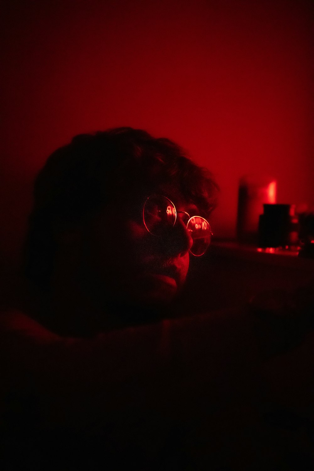 a person wearing glasses in a dark room