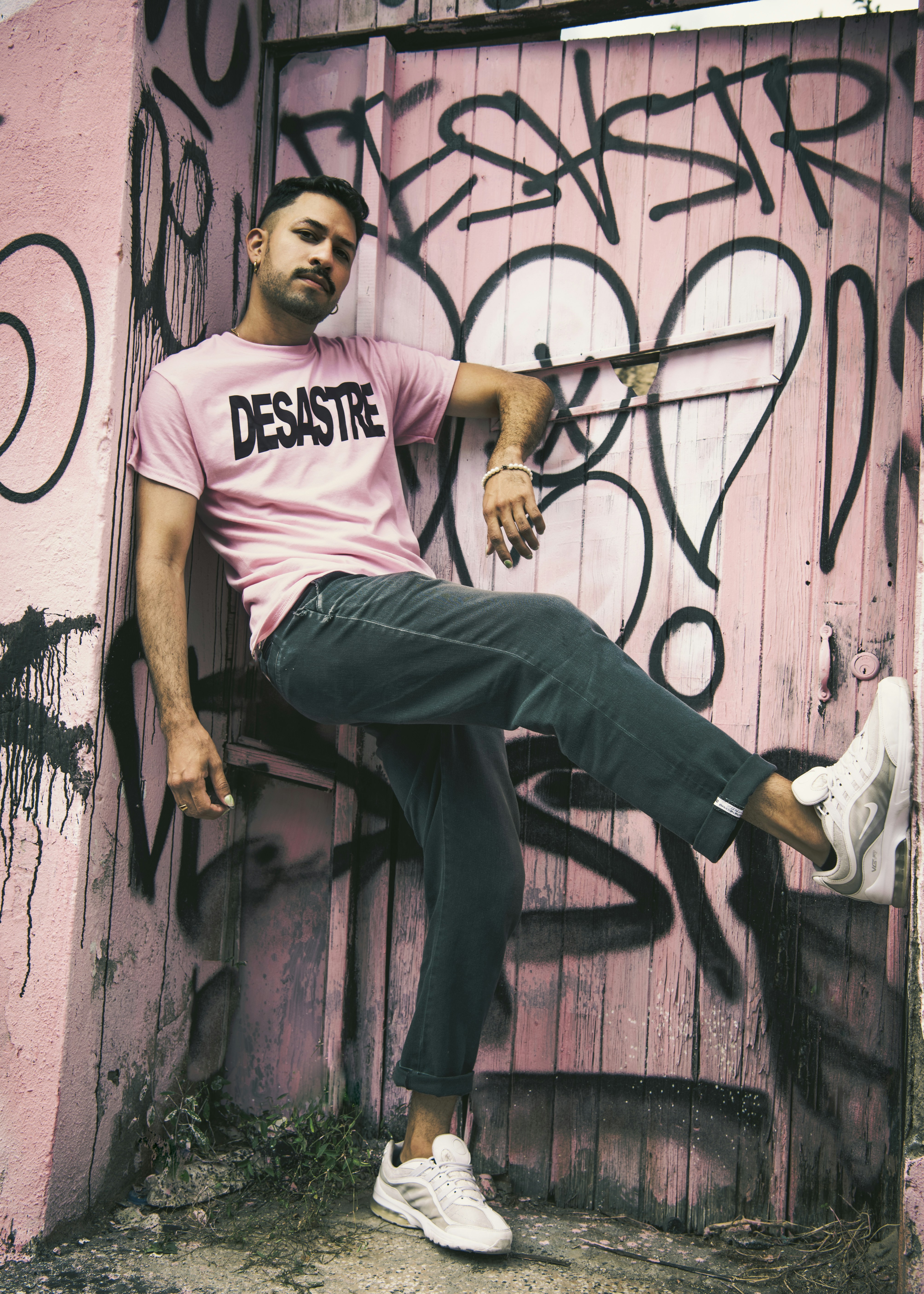 a man in a pink shirt sitting on a door