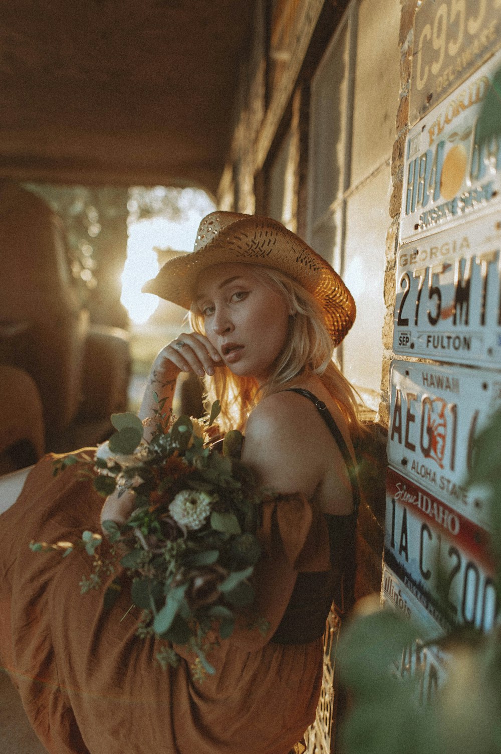 a woman in a straw hat holding a bouquet of flowers