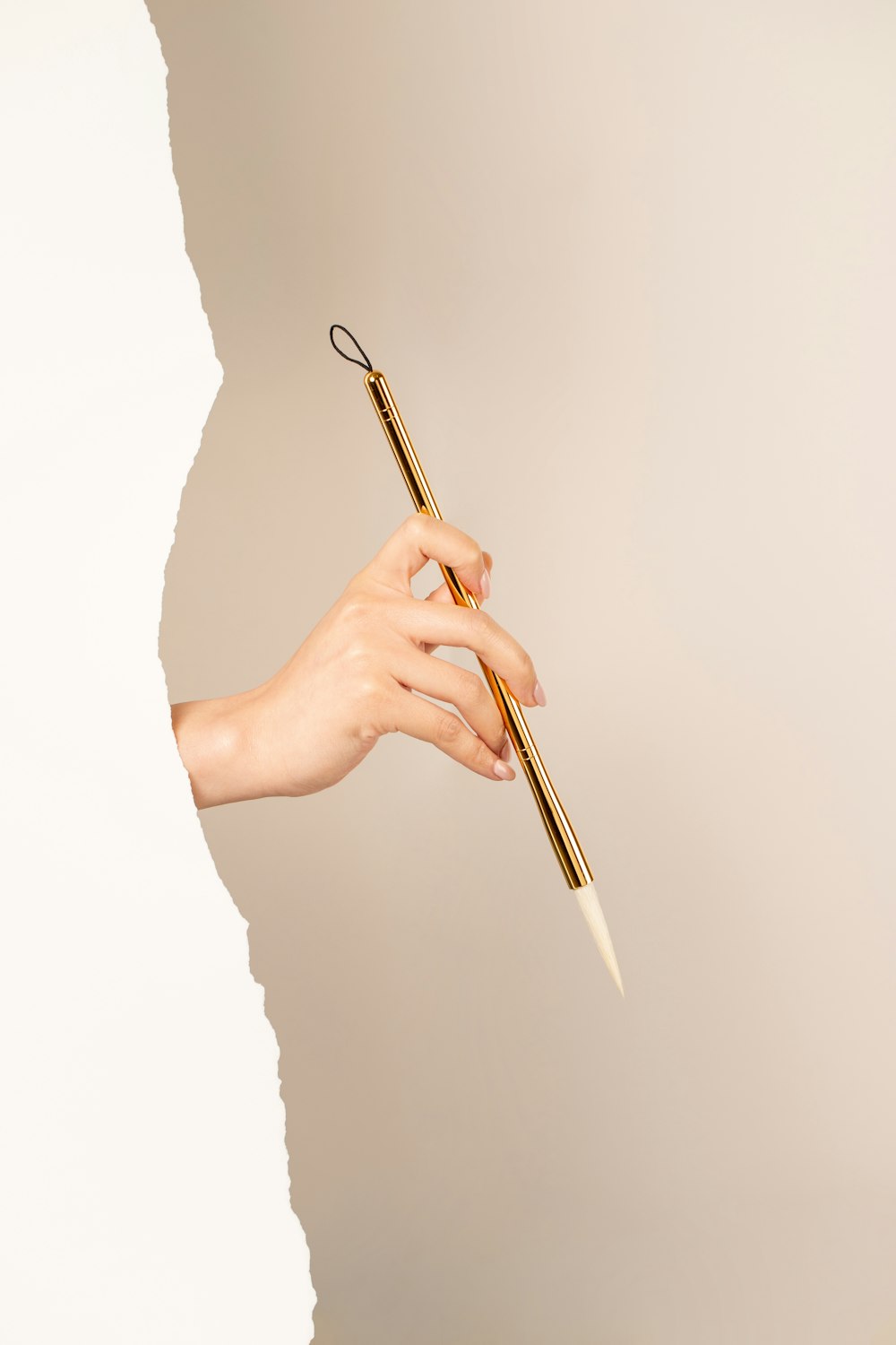 a person holding a golden pen in their hand