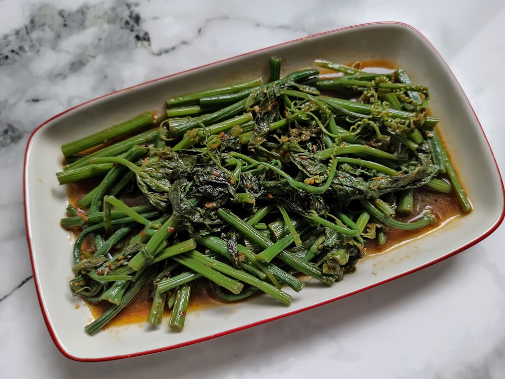 a white plate topped with green beans and broccoli