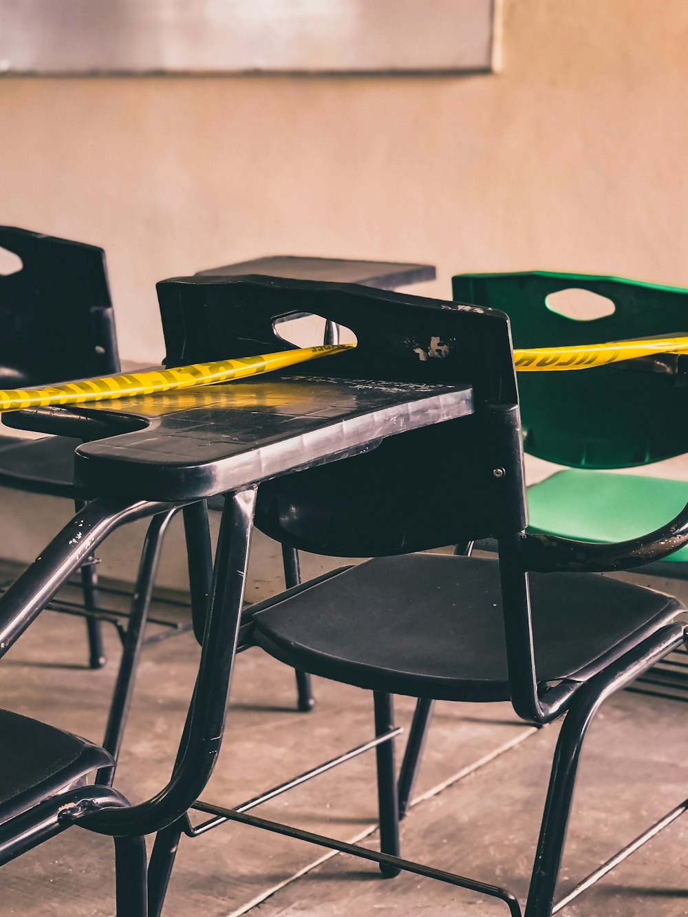 a row of black chairs with yellow tape on them