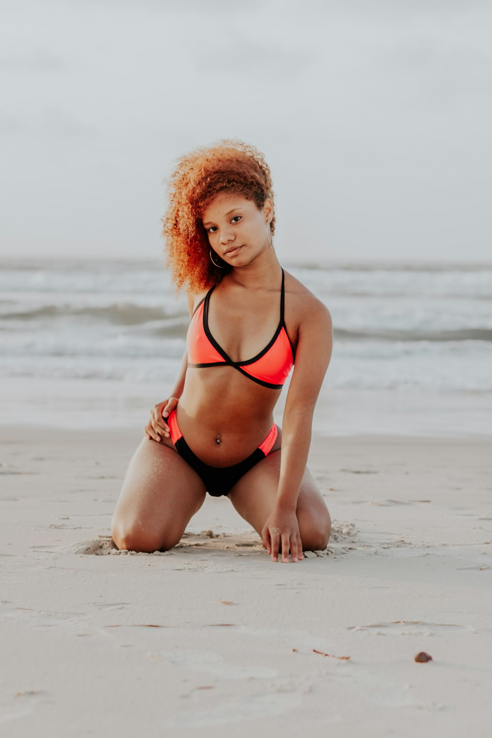 a woman in a bikini sitting on the beach