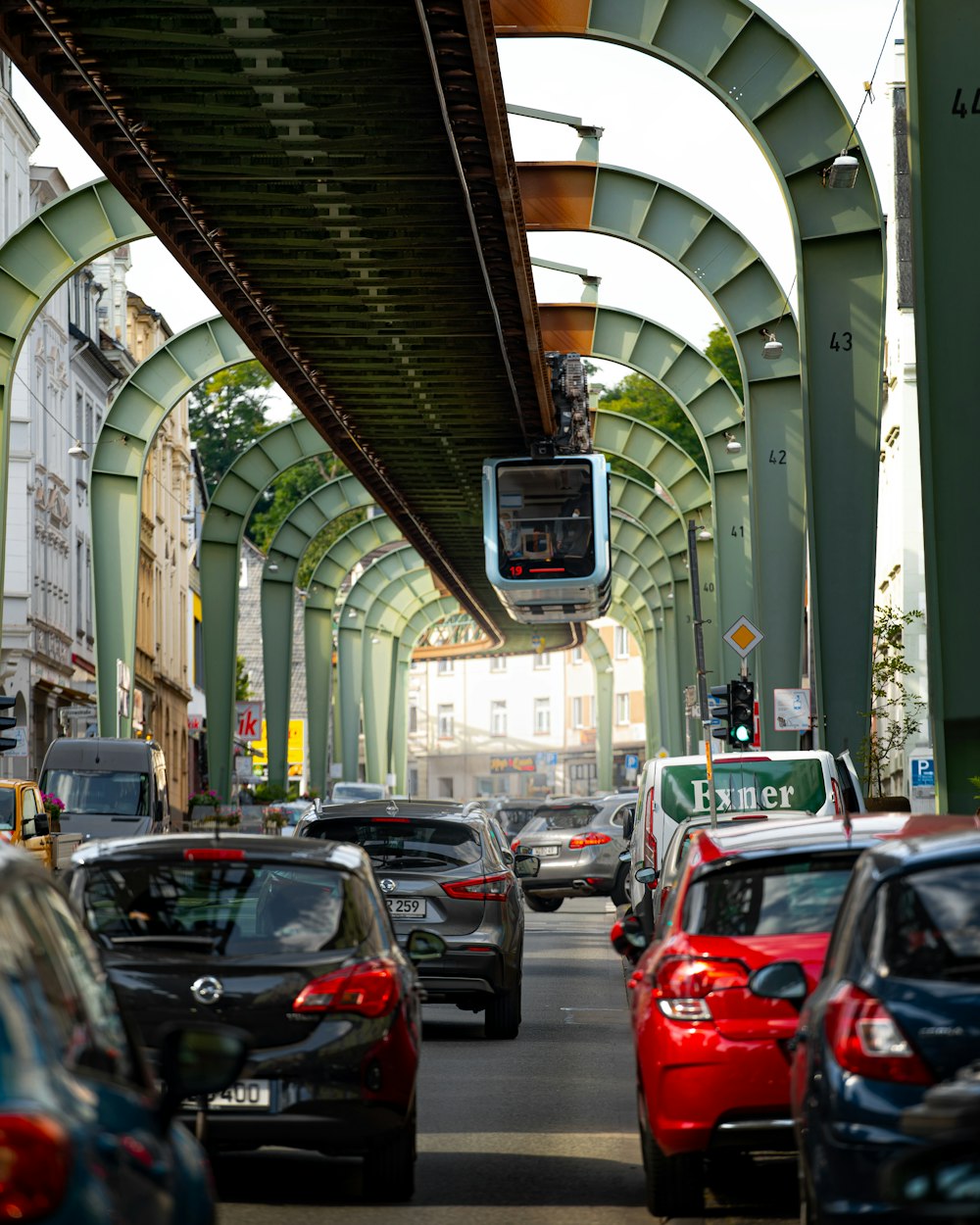 a street filled with lots of traffic under a bridge