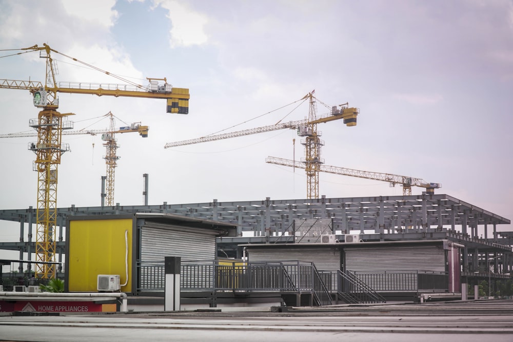 a building under construction with a lot of cranes in the background