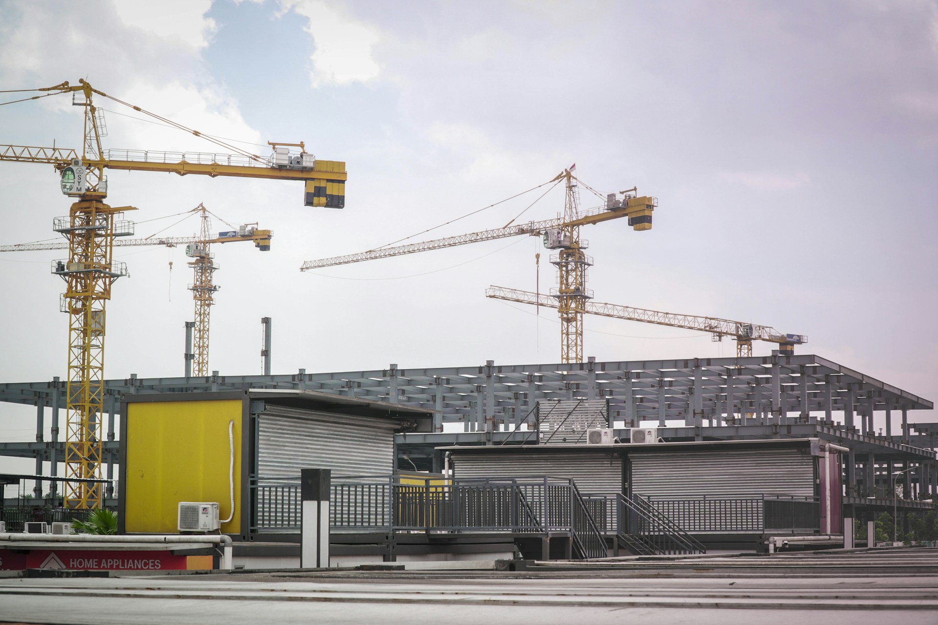 a building under construction with a lot of cranes in the background