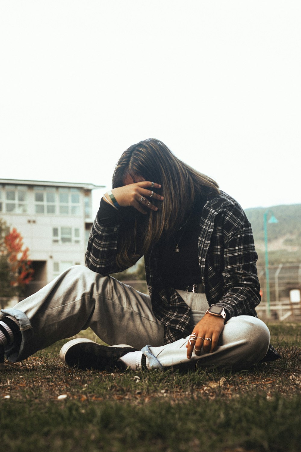 a woman sitting on the ground with her head in her hands