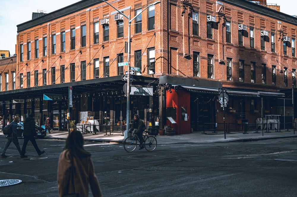 a woman walking across a street next to a tall building