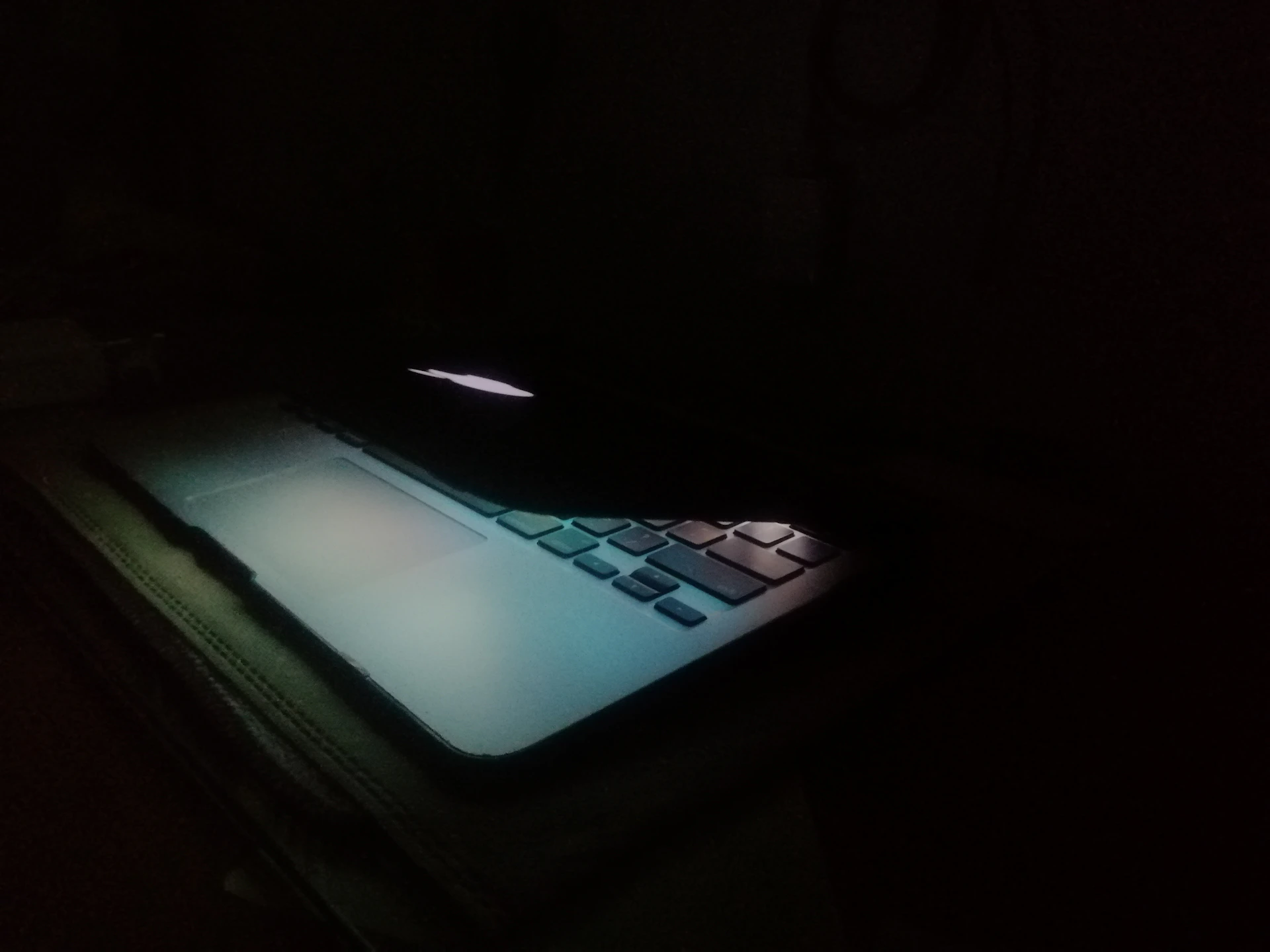 a laptop computer lit up in the dark