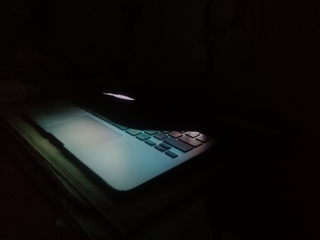 a laptop computer lit up in the dark,