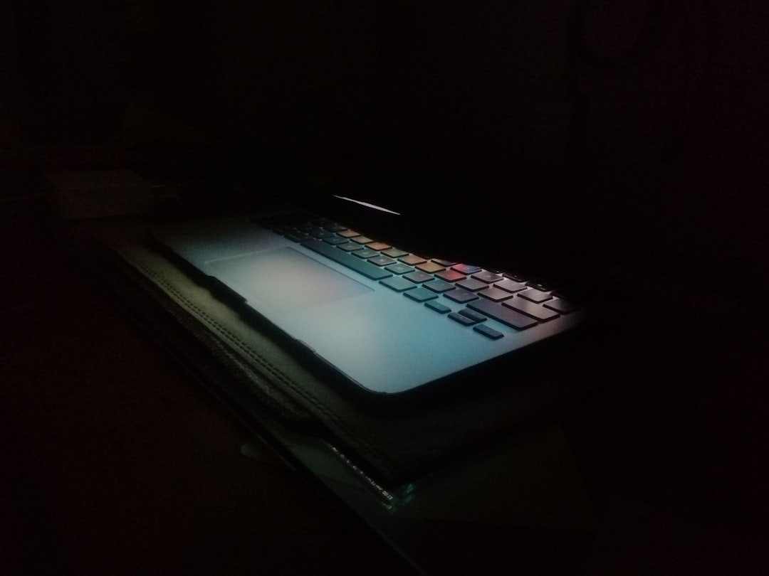 a laptop computer lit up in the dark,