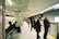 A diverse group of commuters smiling while waiting at a modern urban transit station.