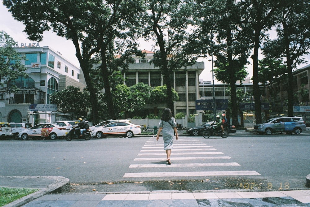 a person walking across a cross walk in the middle of a street