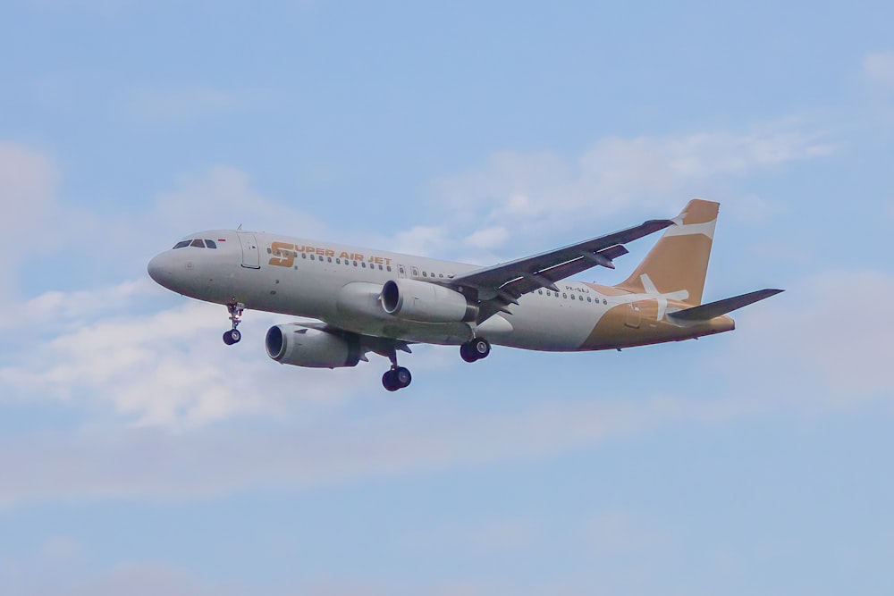 Un gran avión volando a través de un cielo azul nublado