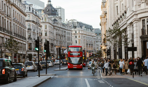 a red double decker bus driving down a busy street