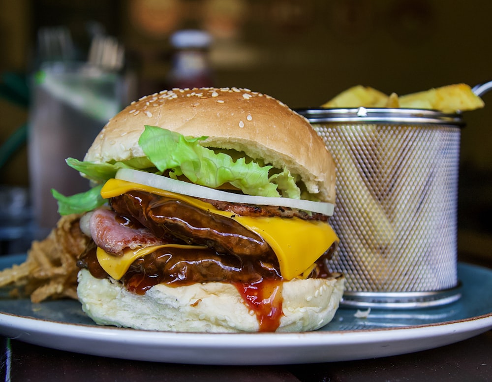 a plate with a hamburger and a cup of chips