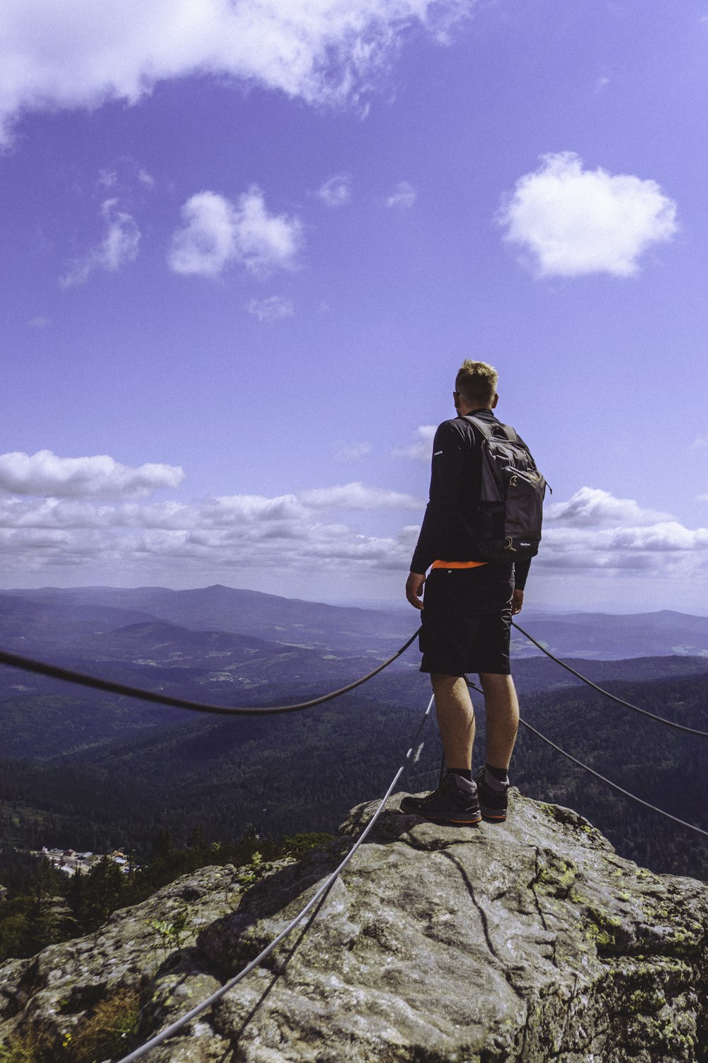 a man standing on top of a mountain with a backpack