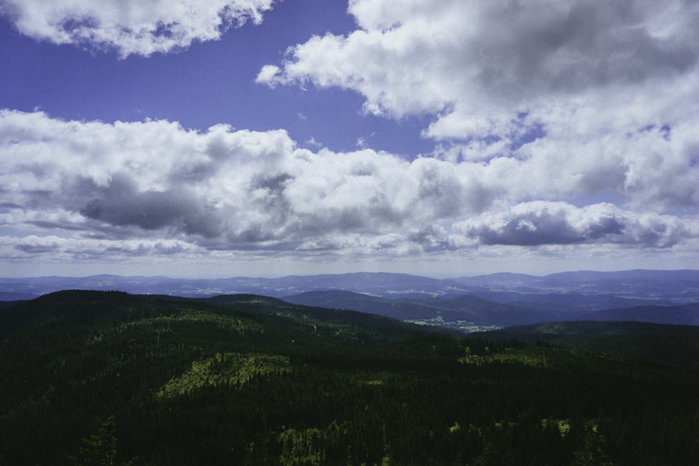 a scenic view of a mountain range under a cloudy sky