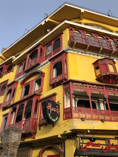 a yellow and red building with red balconies