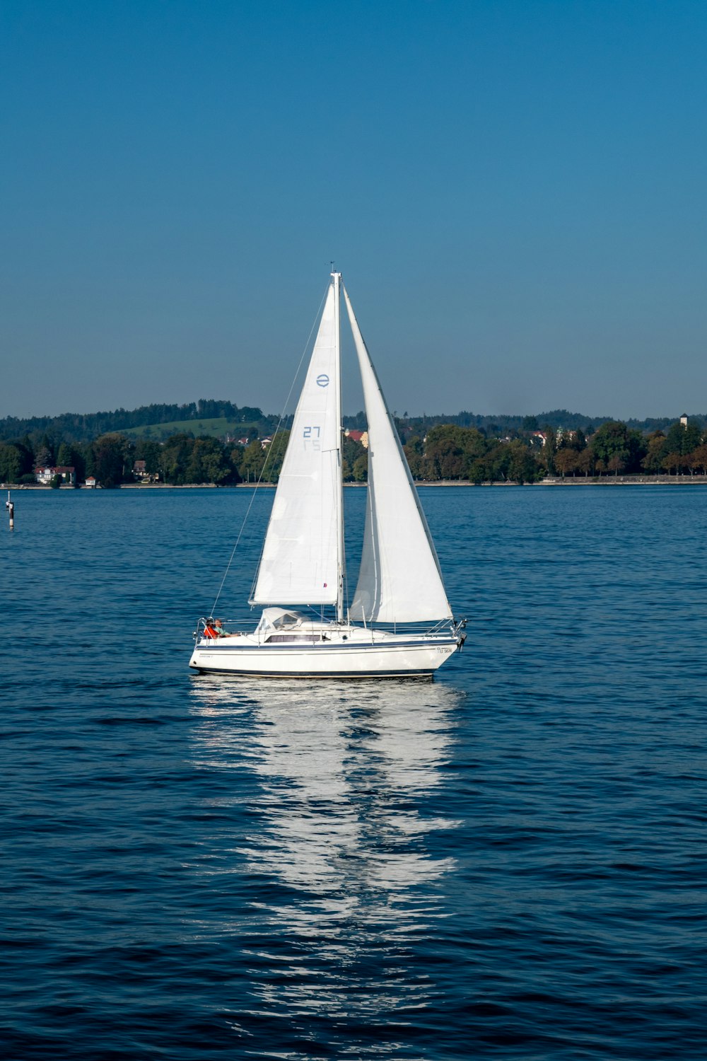 a white sailboat floating on top of a large body of water