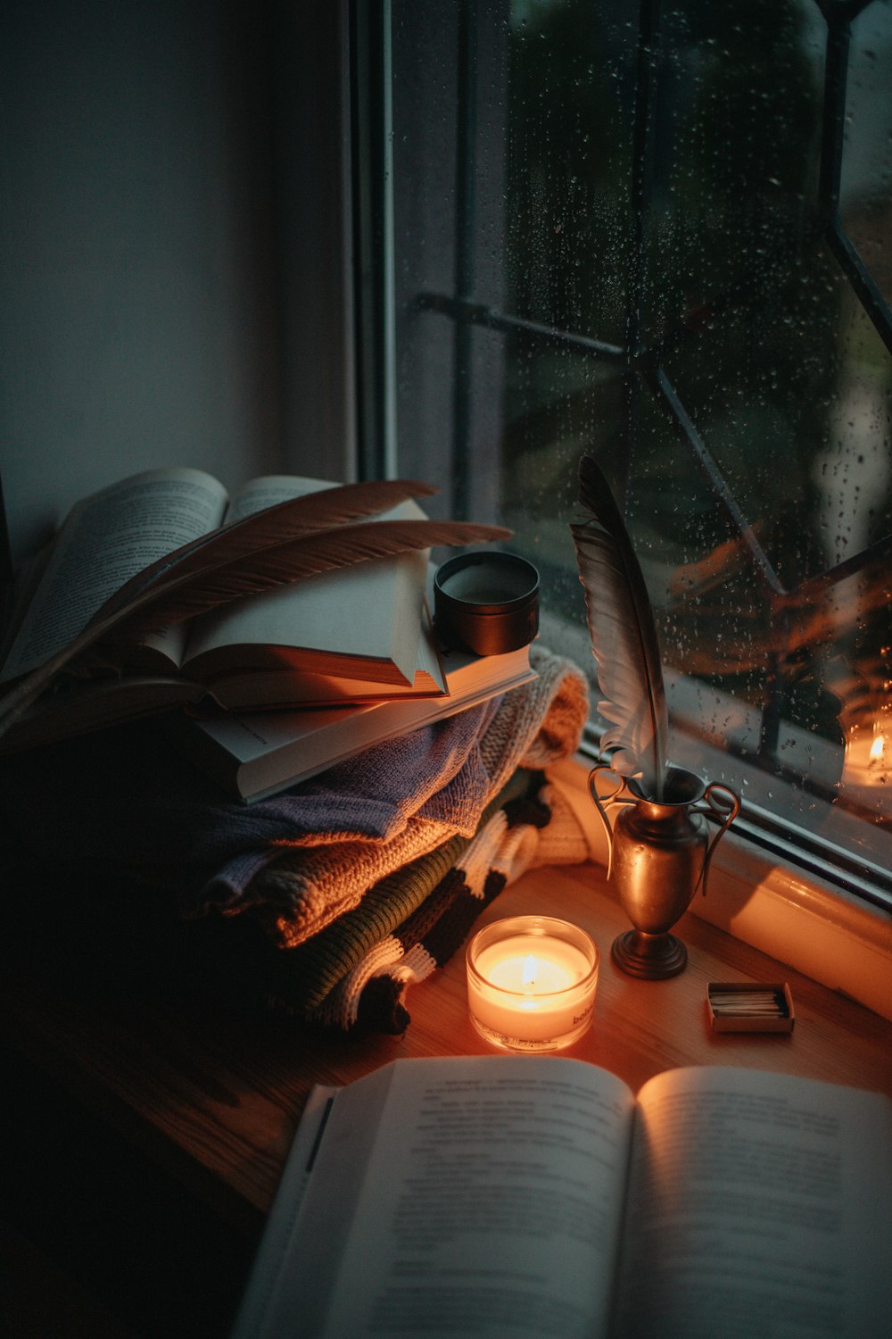 a window sill filled with books and candles