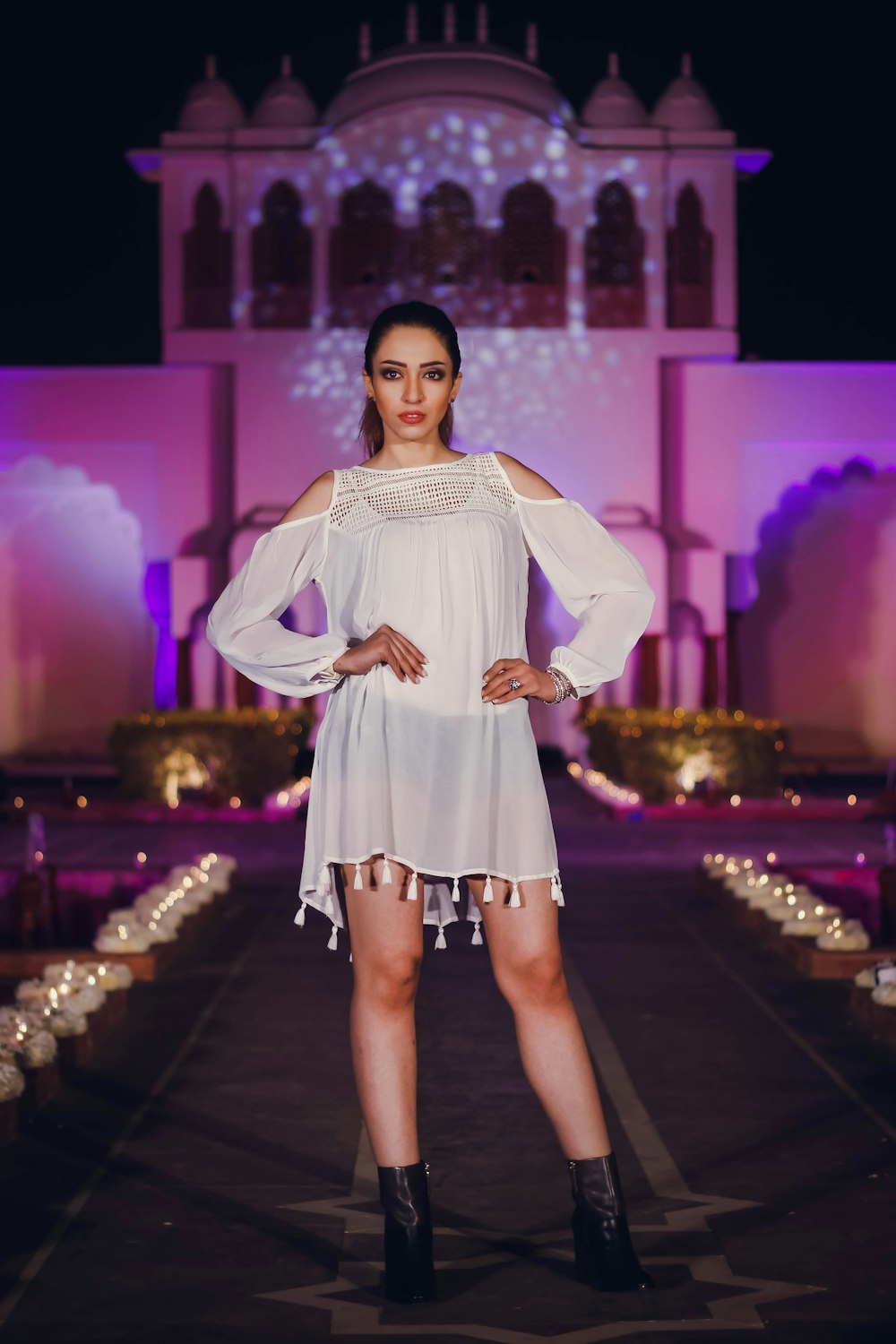 a woman in a white dress standing on a runway