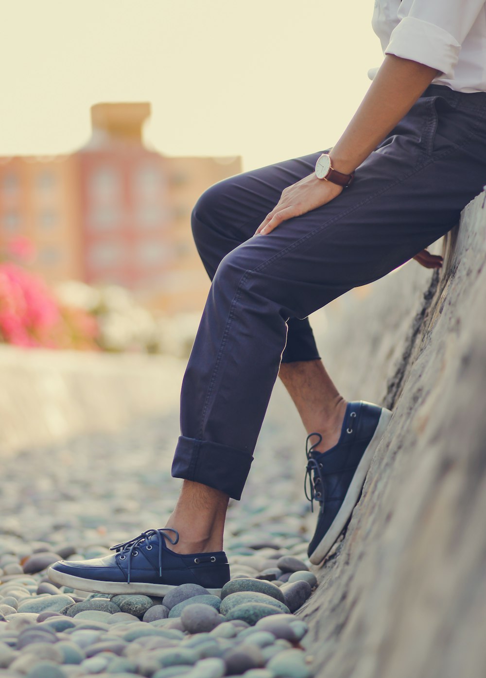 a man is sitting on a rock wall