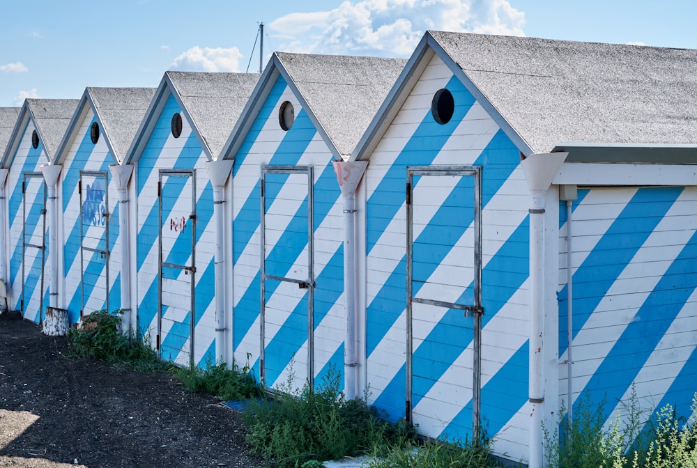 a row of beach huts painted blue and white