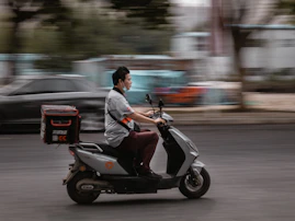 a man riding a scooter down a street