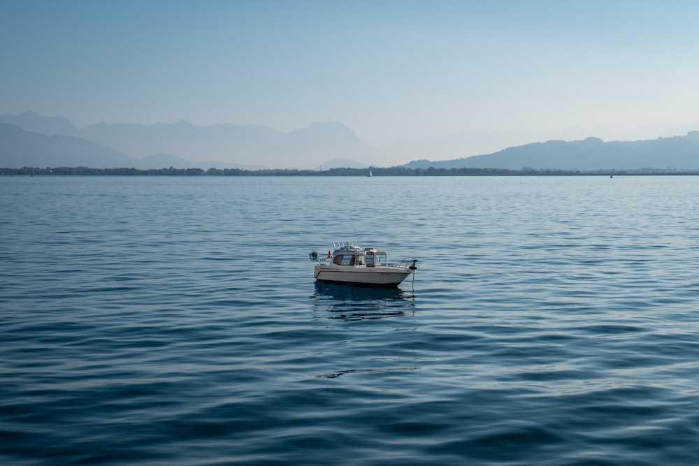 a small boat floating on top of a large body of water