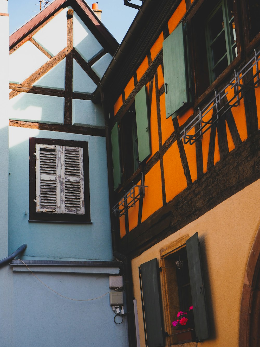 a blue building with a window and shutters