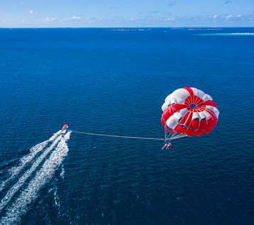 a person is parasailing over the ocean with a boat