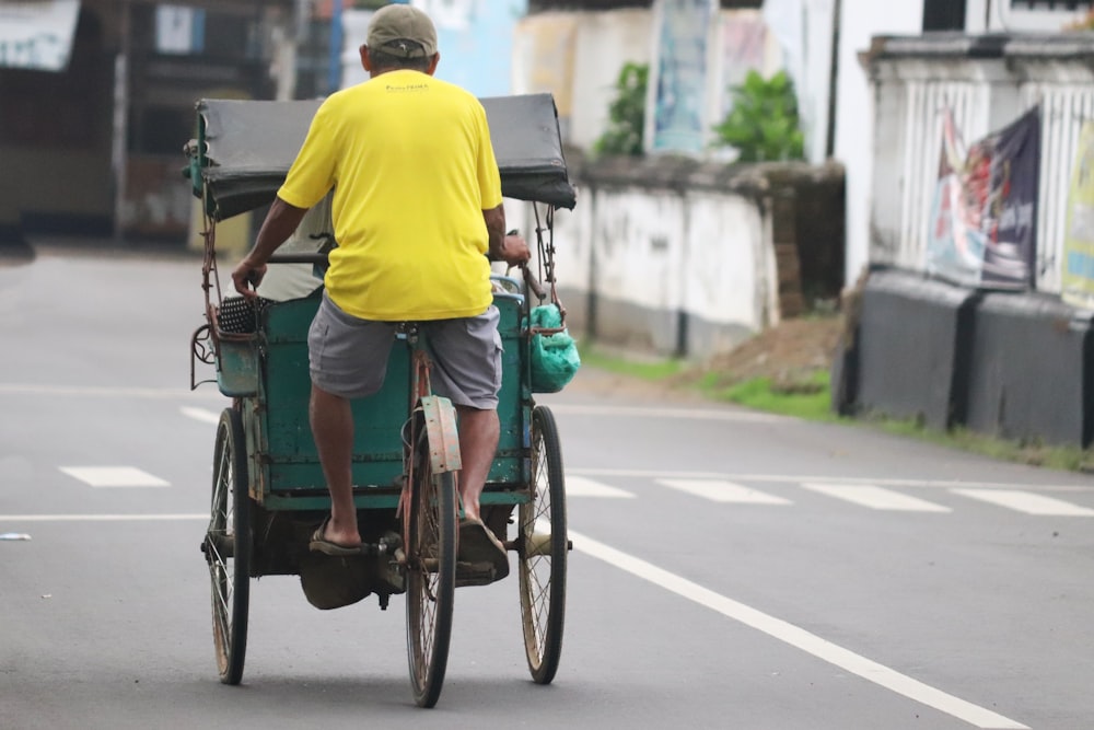 a man riding on the back of a green cart