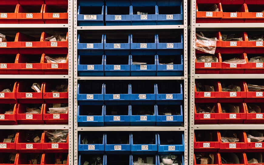a large stack of red, blue, and orange bins