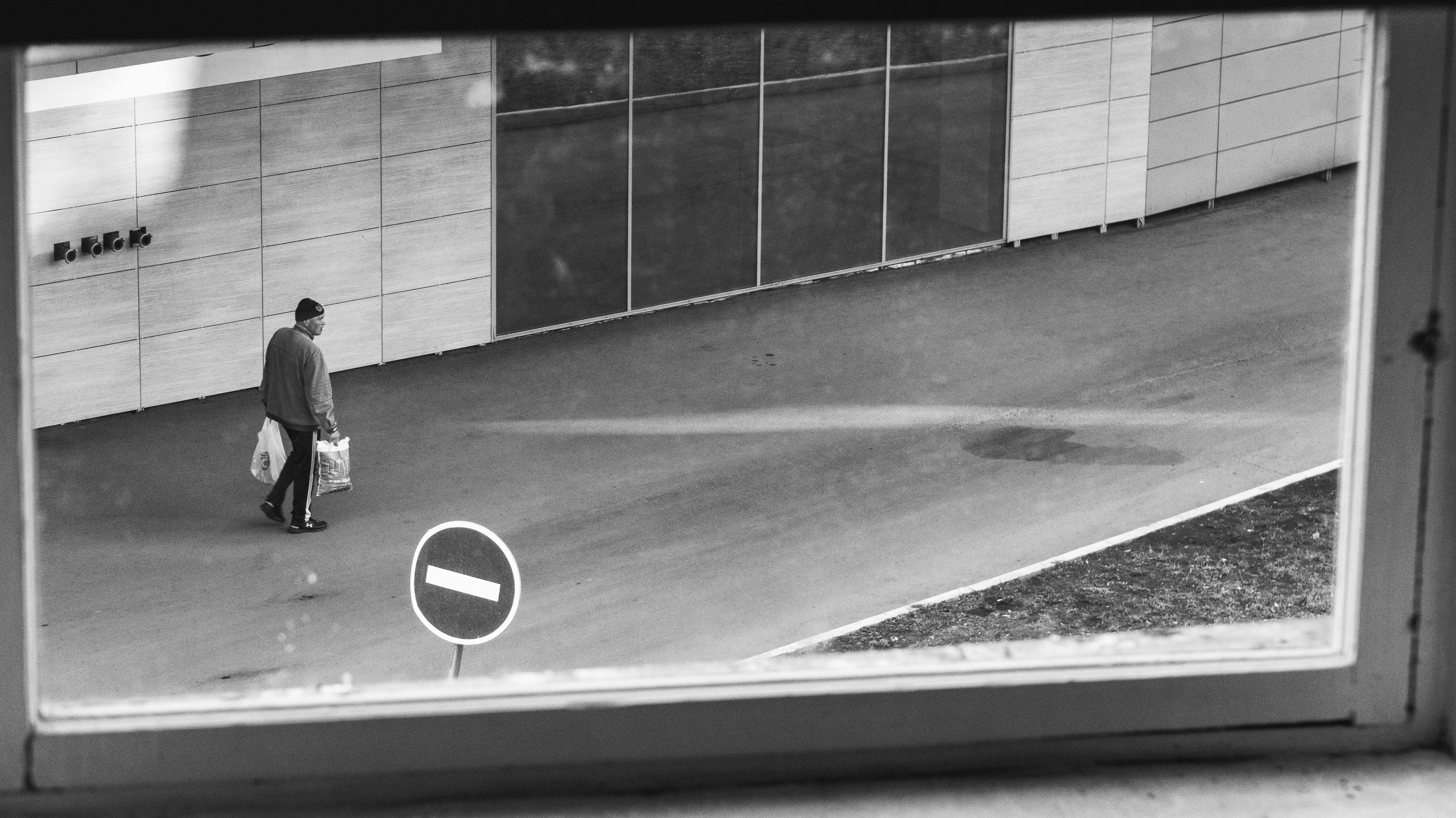 A blurred CCTV footage screenshot showing a person walking, with a magnifying glass highlighting their lower body.