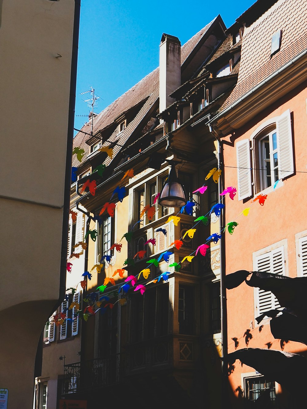 a building with a bunch of kites hanging from it's roof