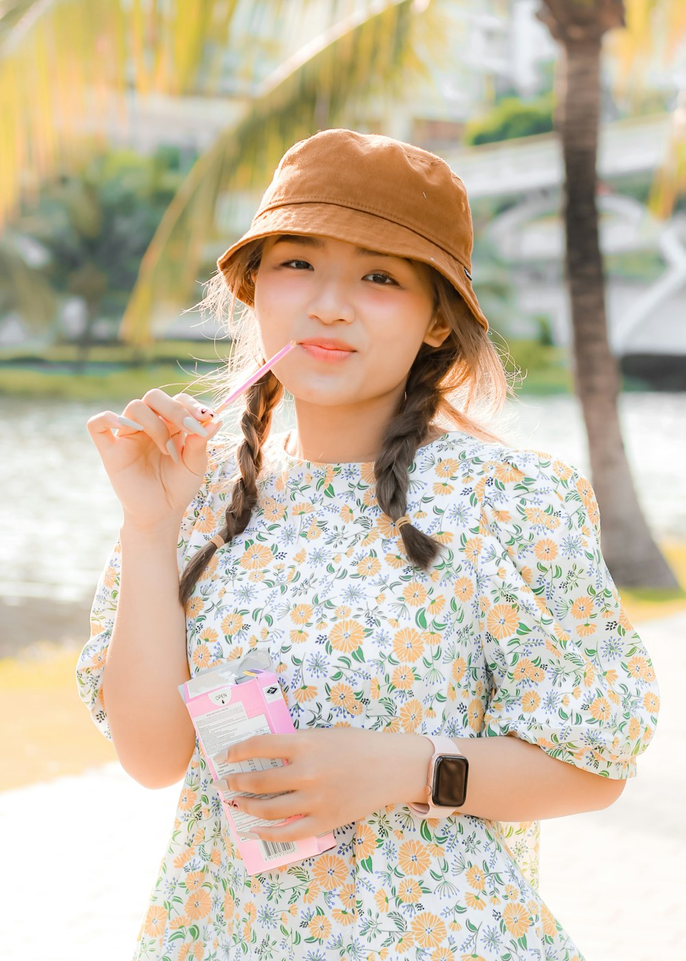 a girl in a hat is brushing her teeth