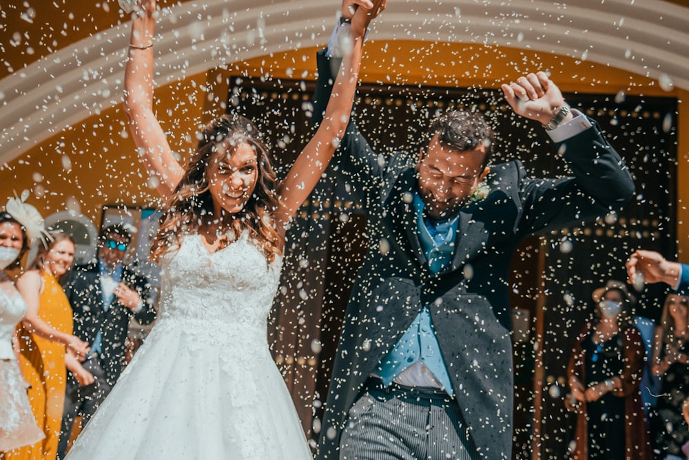 a bride and groom are dancing in the rain