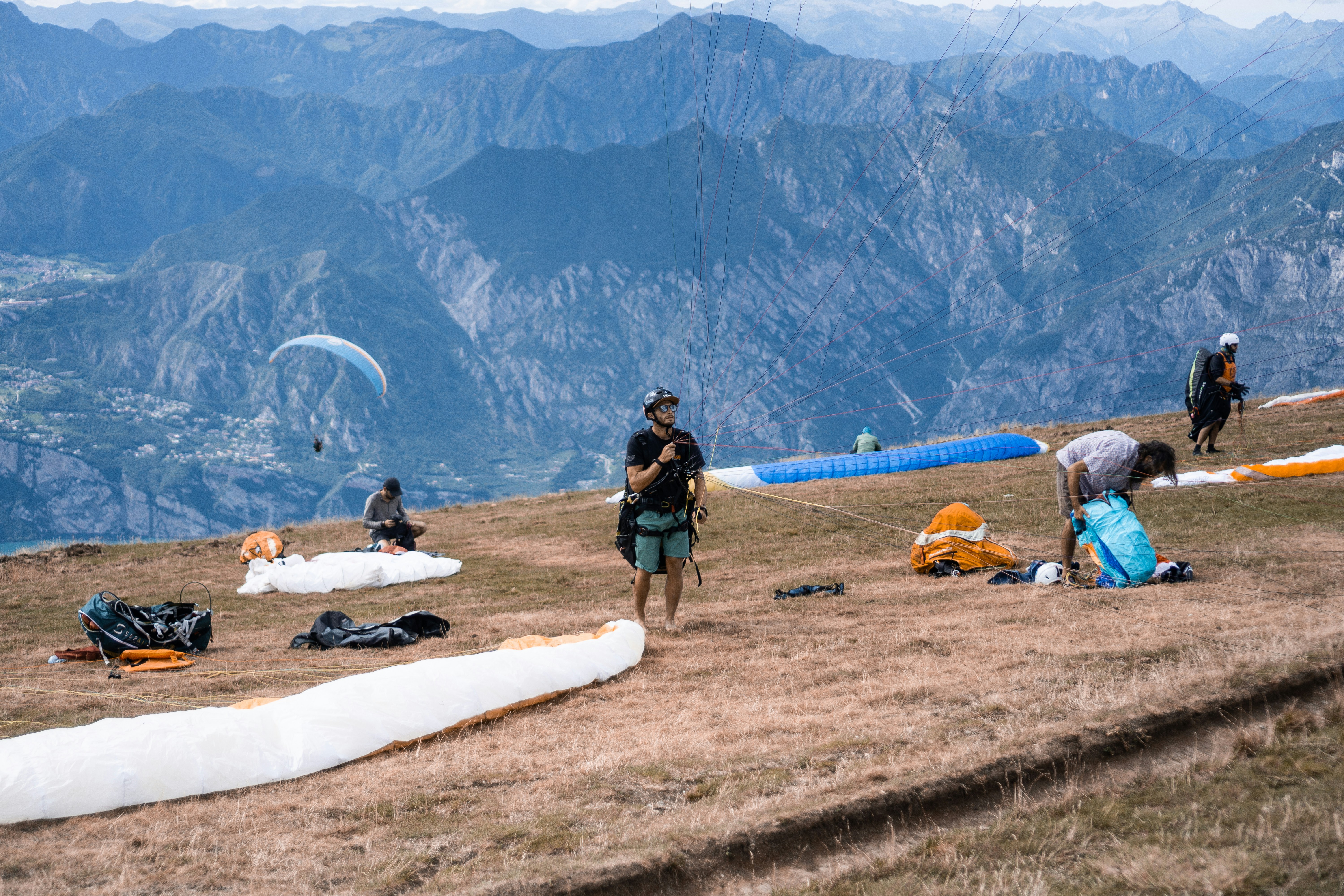 a group of people standing on top of a grass covered hillside
