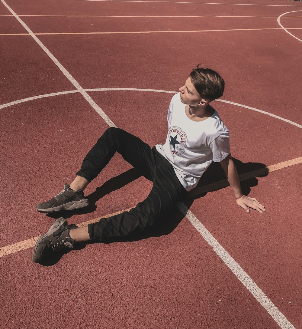 a young man sitting on a basketball court