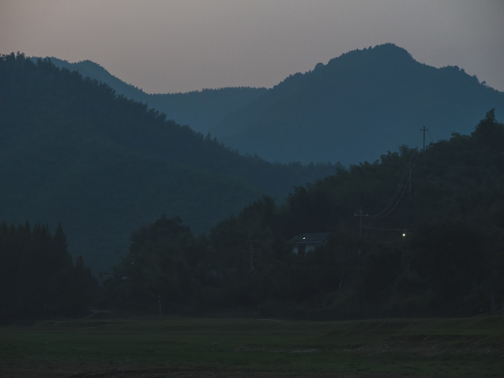 a mountain range with a house in the foreground