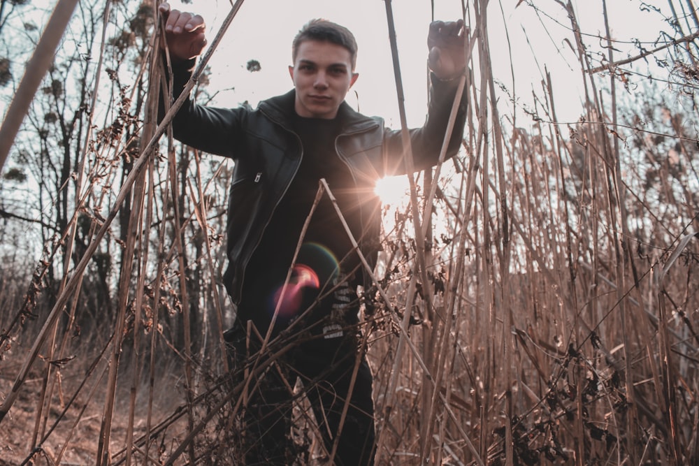 a man standing in a field of tall grass